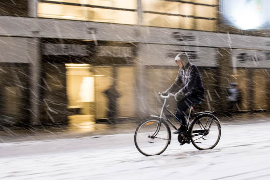 Cyklist utanför arenan i tungt snöoväder