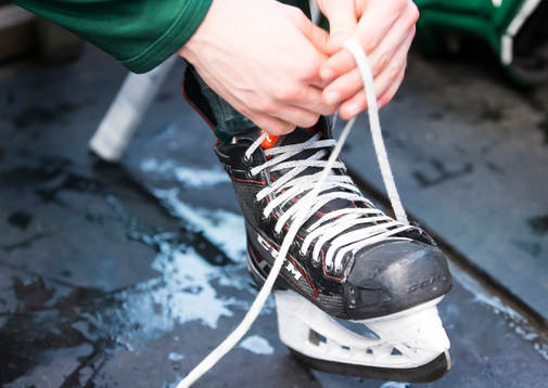 En generell bild av en ishockeyspelare som knyter skridskor
