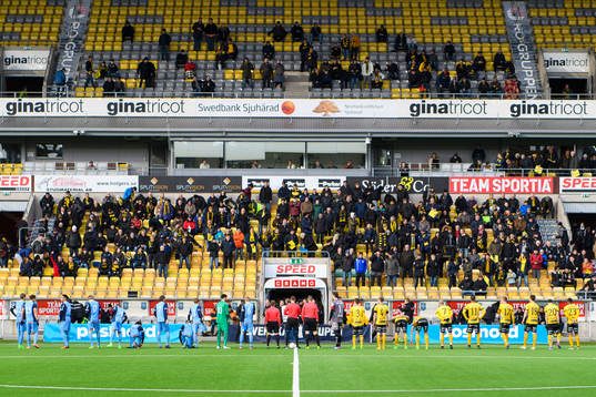 Domarna och spelarna kommer in till fotbollsmatchen i