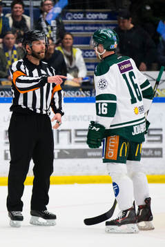 Domaren Marcus Linde ger Färjestads Alexander Johansson en