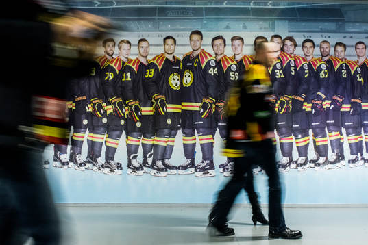 Supportrar passerar ett lagfoto av Brynäs före
