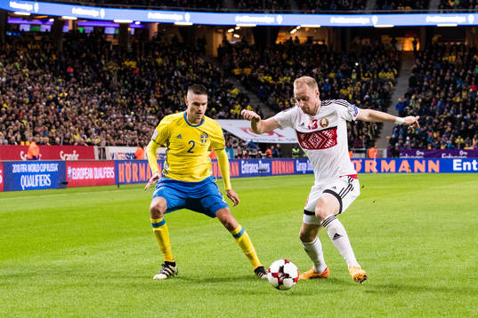 Sveriges Mikael Lustig i kamp om bollen med Belarus Maksim