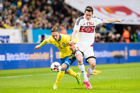 Sveriges Ludwig Augustinsson i kamp om bollen med Belarus