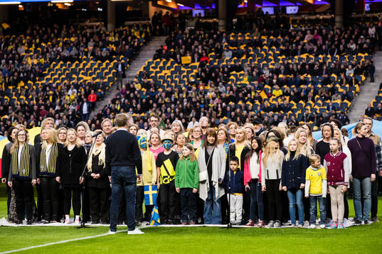 En kör intar planen innan fotbollsmatchen i VM-kvalet