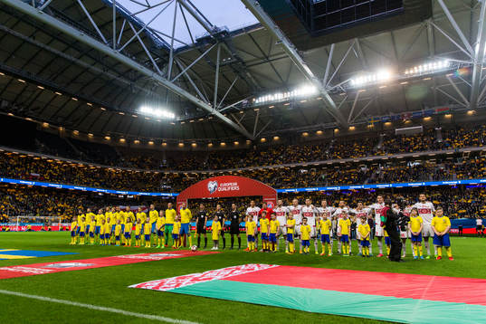 Sveriges och Belarus spelare ställer upp sig på plan innan