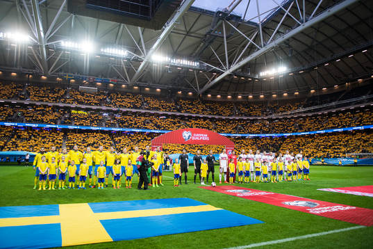 Sverige och Belarus spelare framför ett tifo