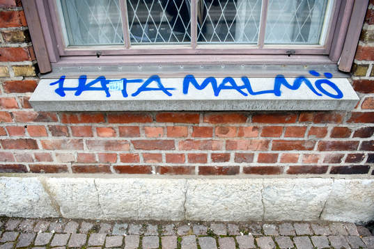 Det står "Hata Malmö" klottrat på en husfasad innan