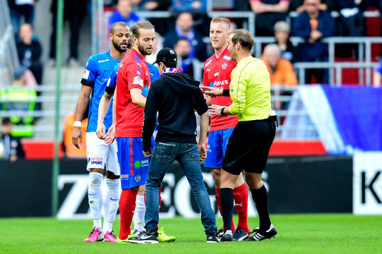 En supporter tar sig in på planen och pratar med