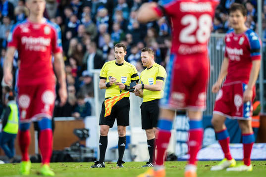 Domare Anders Ekberg samtalar med linjedomaren