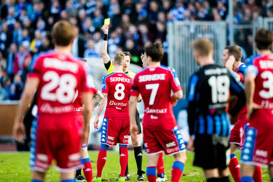 Domare Anders Ekberg delar ut gult kort till IFK Göteborgs