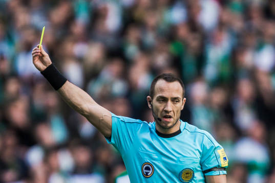 Domare Kaspar Sjöberg delar ut ett gult kort till