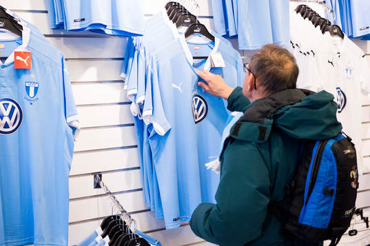En besökare tittar på matchtröjor i Malmö FFs shop