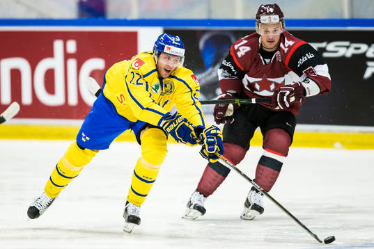 Sveriges Alexander Bergström i kamp om pucken Lettlands