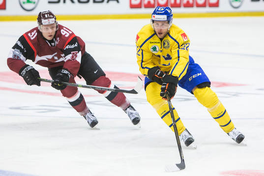 Sveriges Alexander Bergström i kamp om pucken Lettlands