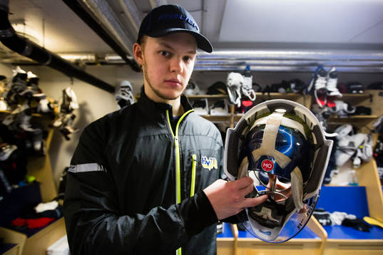 s målvakt Linus Söderström visar upp sin hjälm med en