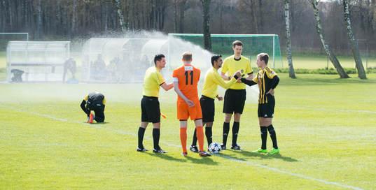 Lagkaptenerna hälsar på domartrion i matchen i division 2
