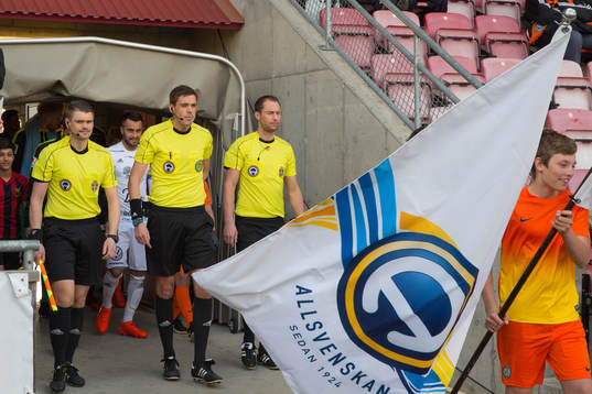 Domare och spelare går in på planen innan fotbollsmatchen