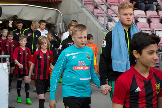 Spelare går in på planen innan fotbollsmatchen i