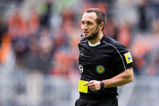 Domare Kaspar Sjöberg tar fram det gula kortet