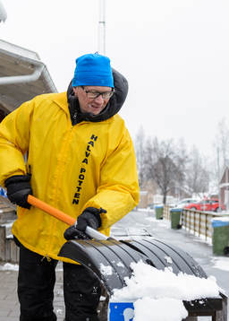 En funktionär skottar bort snö från sittplats