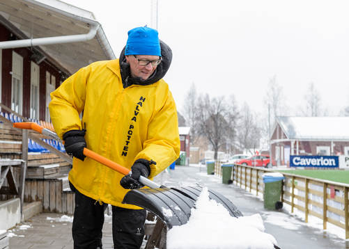 En funktionär skottar bort snö från sittplats