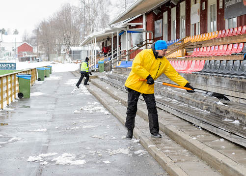 En funktionär skottar bort snö från sittplats
