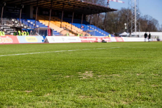 Torra fläckar i gräset innan fotbollsmatchen i