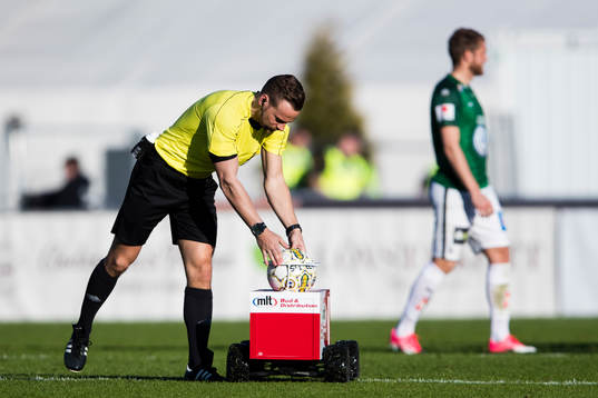 Domare Kristoffer Karlsson plockar upp matchbollen från en
