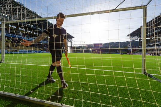 Assisterande domaren kollar nätet innan fotbollsmatchen i