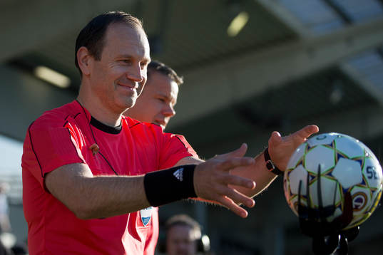 Domare Jonas Eriksson tar matchbollen innan fotbollsmatchen