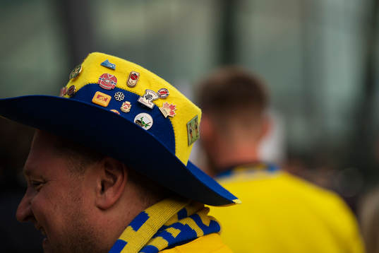 Ett svenskt fan har på sig en hatt med pins