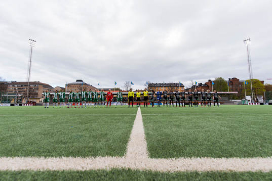 Spelare och domare ställer upp sig innan fotbollsmatchen i