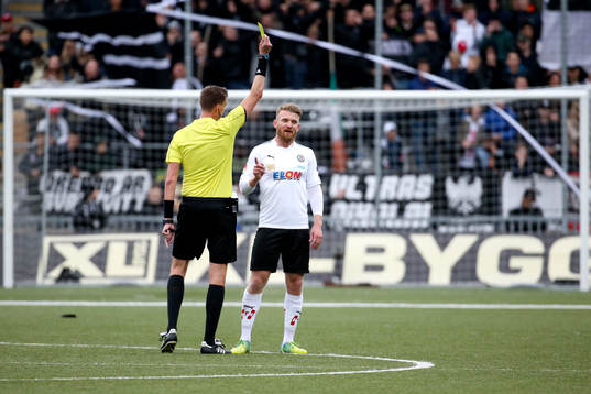 Örebros Michael Almebäck får gult kort av domare Magnus