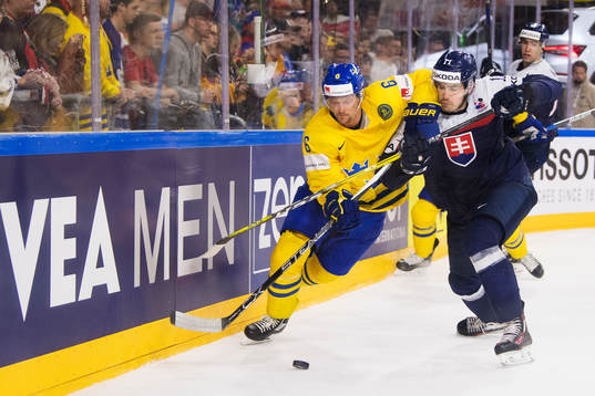 Sveriges Anton Strålman kämpar om pucken mot Slovakiens