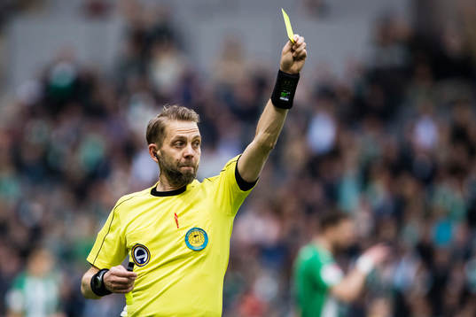 Domare Johan Hamlin delar ut ett gult kort