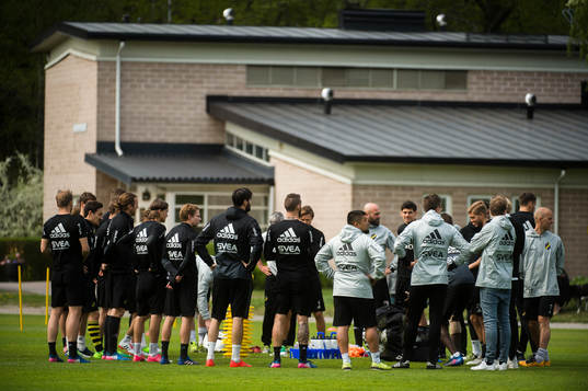 Spelarna och ledare samlade före  en fotbollsträning med