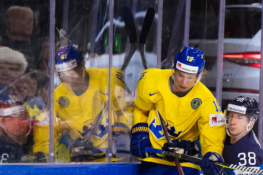 Sveriges Nicklas Bäckström blir tacklad av Finlands Juuso