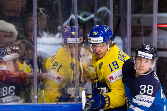 Sveriges Nicklas Bäckström blir tacklad av Finlands Juuso