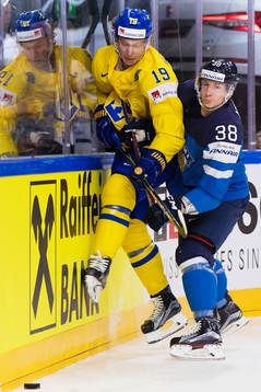 Sveriges Nicklas Bäckström blir tacklad av Finlands Juuso