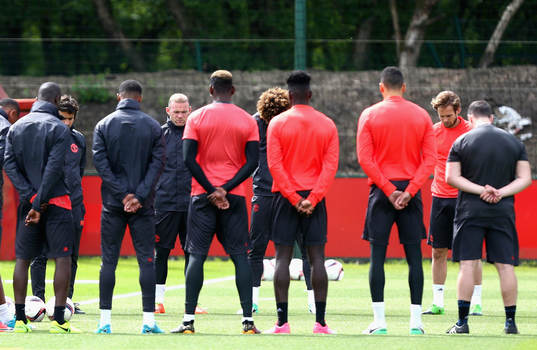 The Manchester United players and staff hold a minute