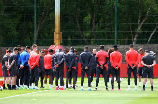 The Manchester United players and staff hold a minute
