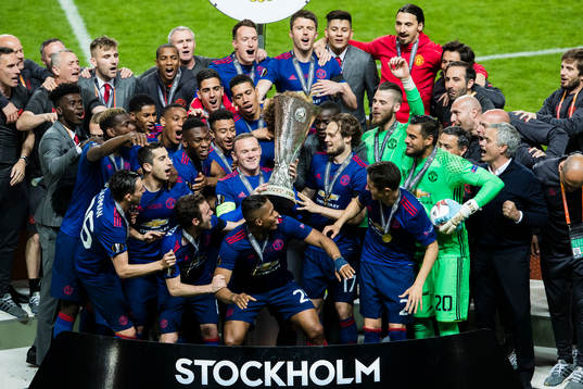 Manchester Uniteds Wayne Rooney håller upp pokalen och