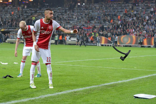 Ajax Hakim Ziyech kastar undan delar av en stol som lagets