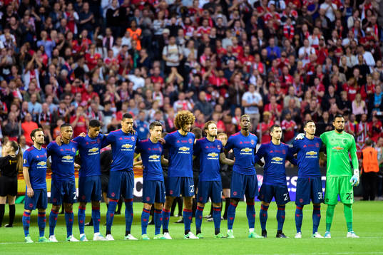 Manchester Uniteds spelare i en tyst minut för offren