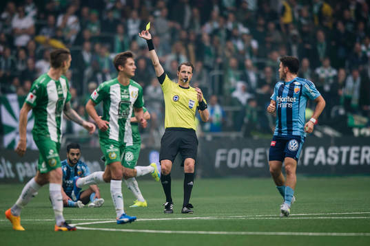 Domare Andreas Ekberg delar ut ett gult kort till Hammarbys