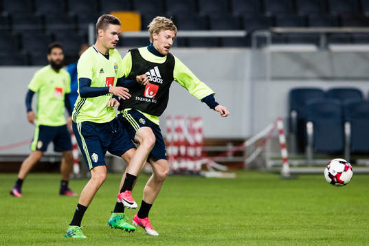 Sveriges Mikael Lustig i kamp om bollen med Emil Forsberg