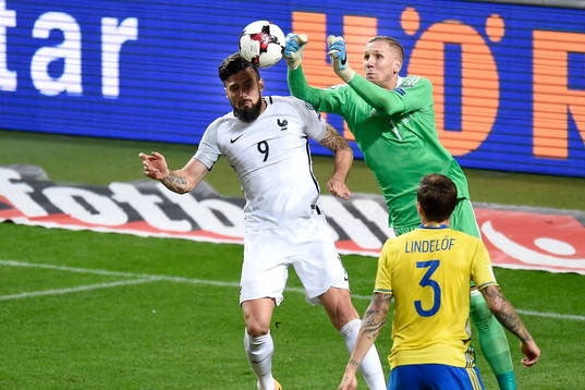 Sveriges målvakt Robin Olsen (h) boxar undan bollen