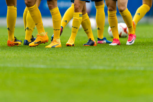 Fotbollskor på gräsplan