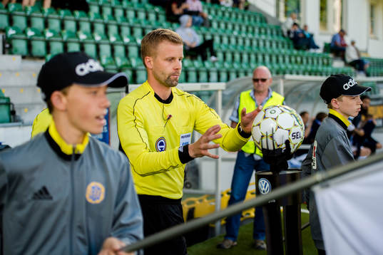 Domare Glenn Nyberg tar matchbollen innan fotbollsmatchen i