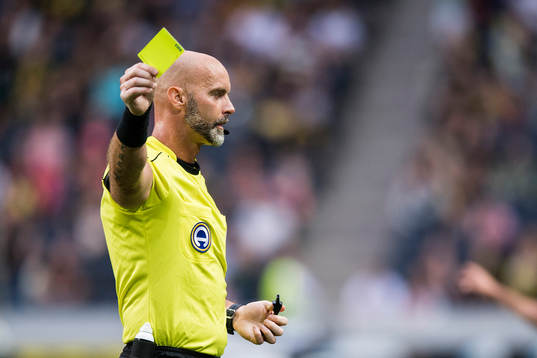 Domare Stefan Johannesson delar ut ett gult kort